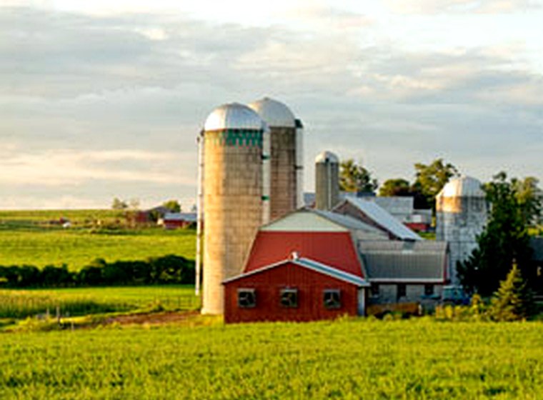 An Iowa farm with silos at sunset