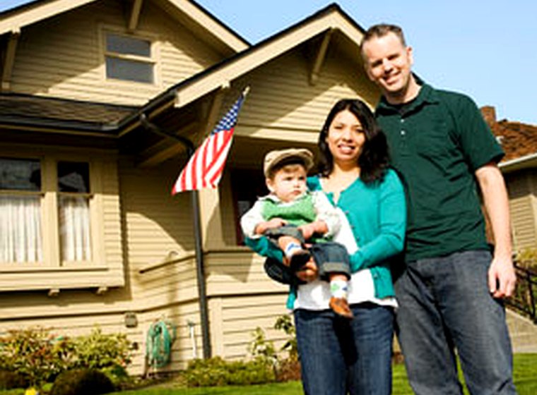 A young family outside their rented home